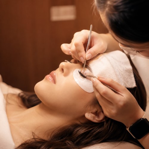 A lash artist carefully applying extensions during an appointment